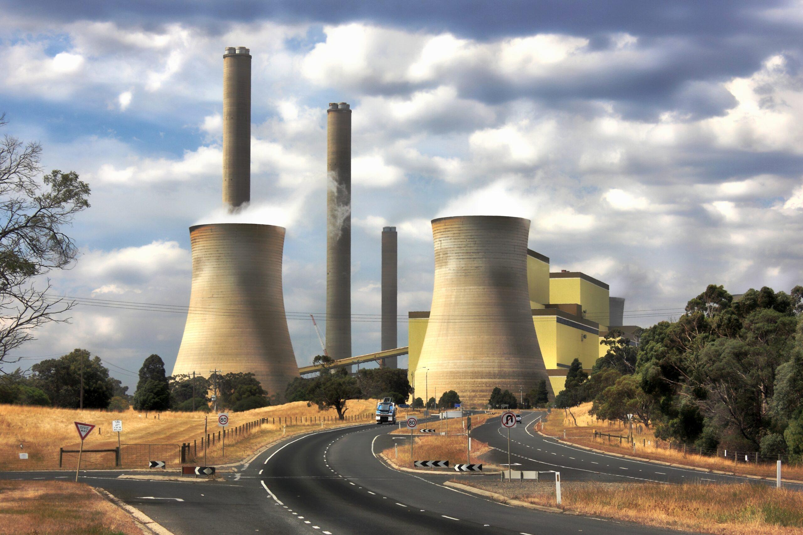 Power station with cooling towers and smokestacks