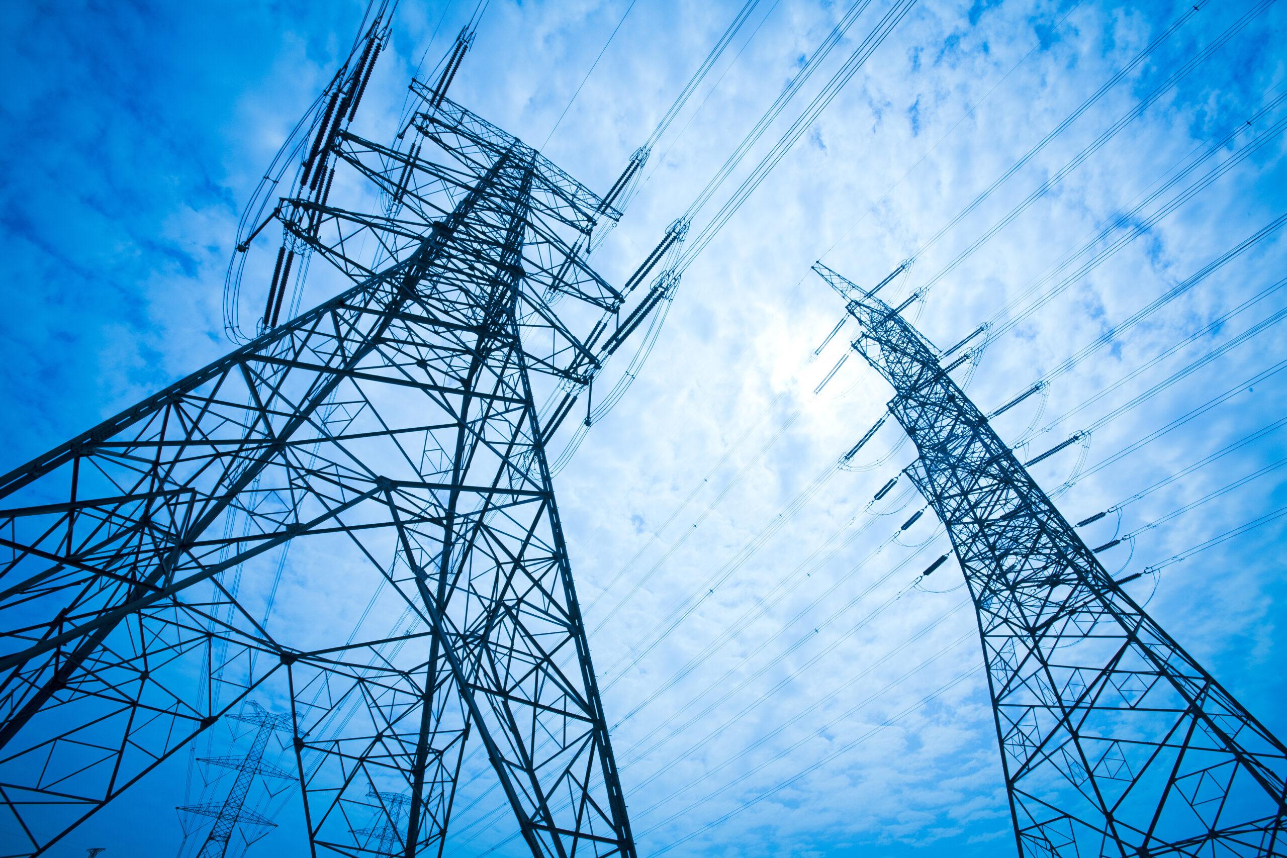 Power transmission towers against blue sky